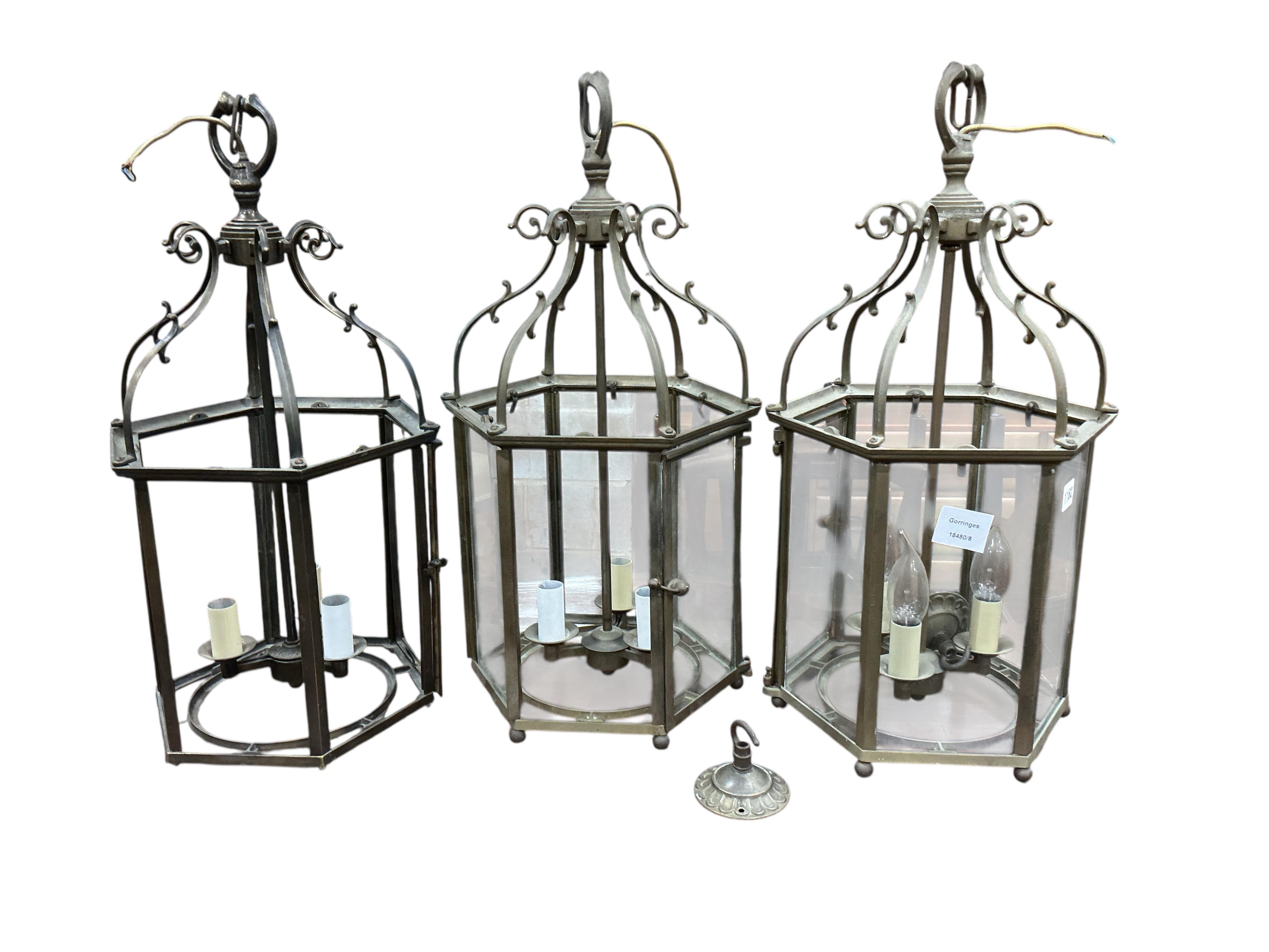 A set of three hexagonal brass hall lanterns, one lacks glass panels